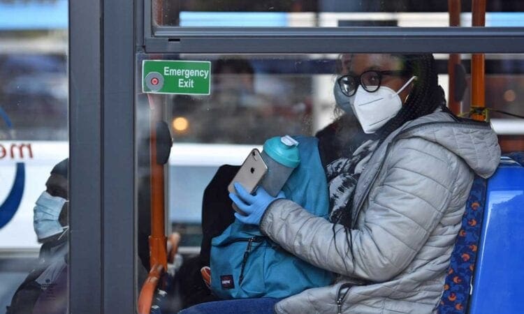 Woman wearing face covering on bus